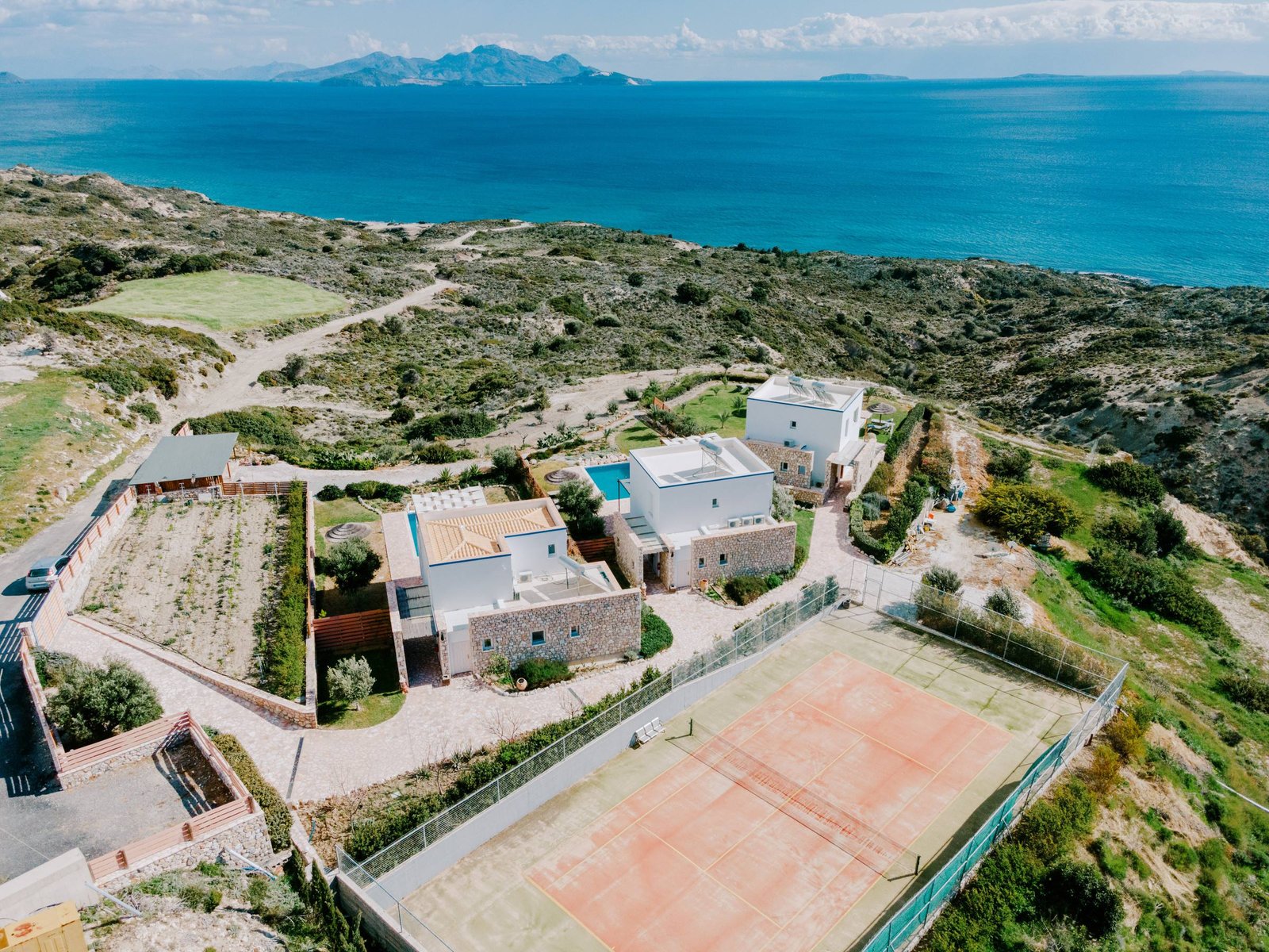 Private tennis court next to the villas, Aegean and islands in the distance
