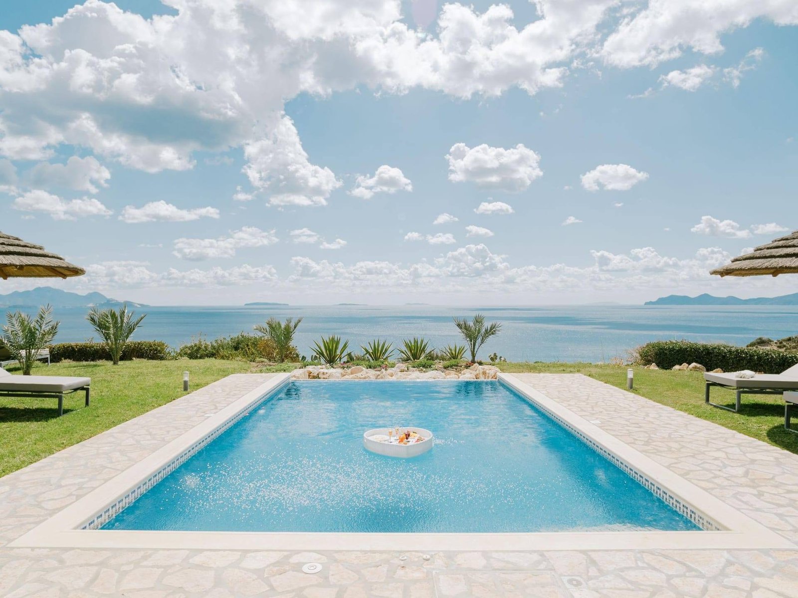 Villa Afrodite private pool with sea view and thatched umbrellas