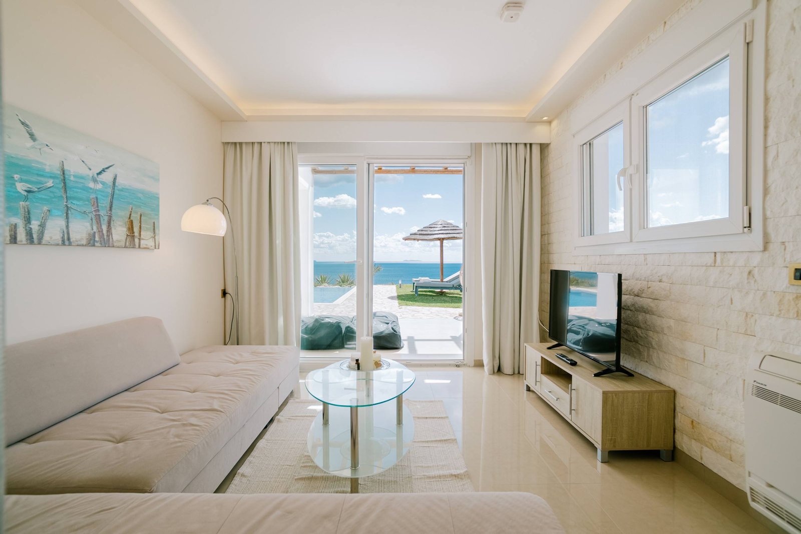 Living room with TV and view to the pool and sea