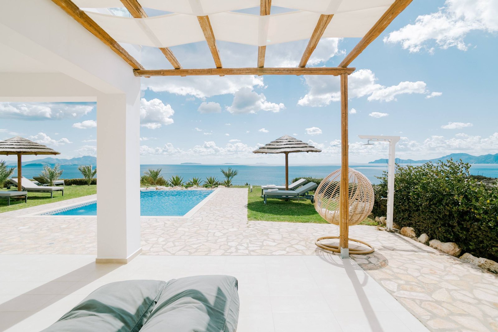 Pergola terrace with hanging egg chair and sea view