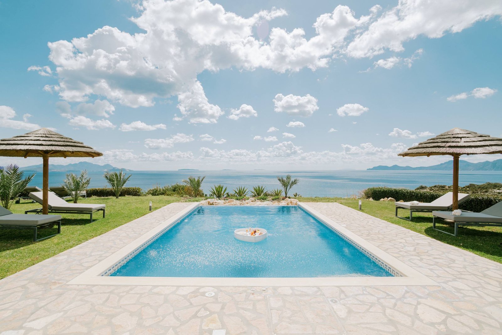 Private pool with thatched umbrellas and sea view to the islands